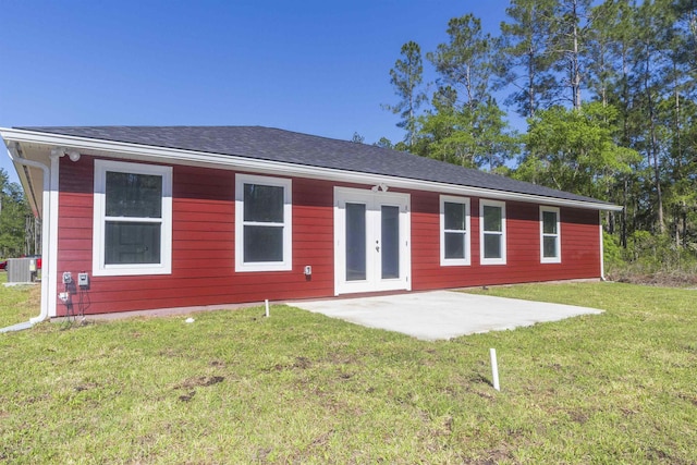 rear view of property featuring french doors, a patio, central AC, and a lawn