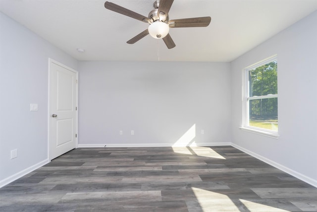 empty room featuring a wealth of natural light, dark wood-type flooring, and ceiling fan