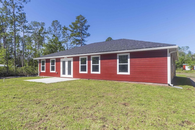 rear view of property with a lawn, a patio area, and french doors