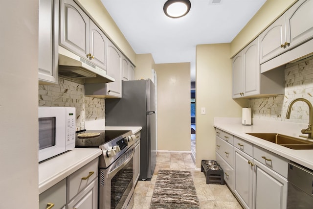 101 Vista Lagoon Ct Unit A-4, Ponte Vedra Beach, FL 32082 - kitchen featuring appliances with stainless steel finishes, a sink, under cabinet range hood, and backsplash