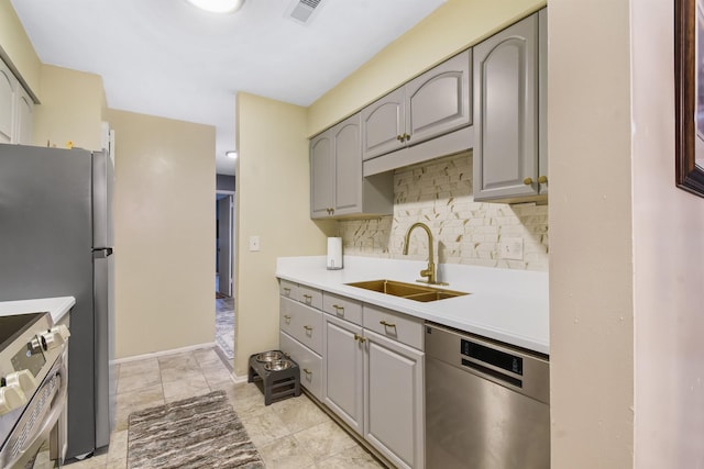 101 Vista Lagoon Ct Unit A-4, Ponte Vedra Beach, FL 32082 - kitchen with stainless steel appliances, a sink, gray cabinetry, and tasteful backsplash