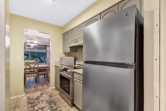 101 Vista Lagoon Ct Unit A-4, Ponte Vedra Beach, FL 32082 - kitchen with stainless steel appliances, a chandelier, under cabinet range hood, and gray cabinetry