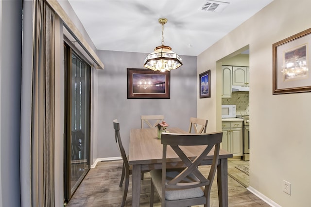 101 Vista Lagoon Ct Unit A-4, Ponte Vedra Beach, FL 32082 - dining area with a chandelier, light wood-type flooring, and baseboards