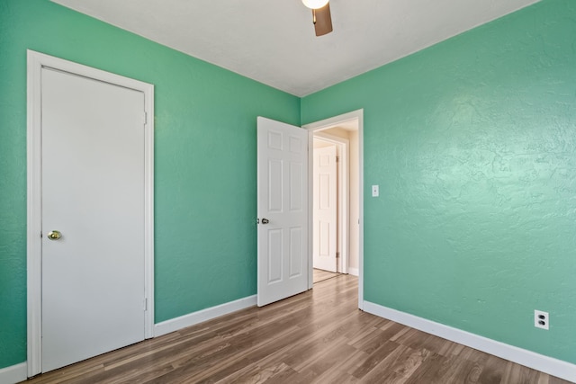 unfurnished bedroom featuring ceiling fan and hardwood / wood-style flooring