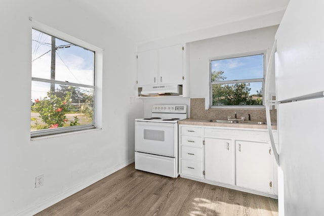 kitchen with white cabinets, white appliances, light hardwood / wood-style flooring, and sink