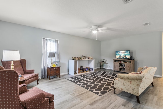 sitting room with a textured ceiling, light hardwood / wood-style floors, and ceiling fan