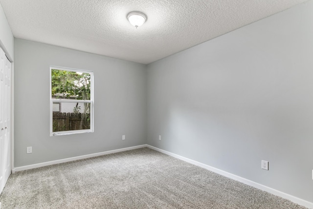 carpeted spare room featuring a textured ceiling