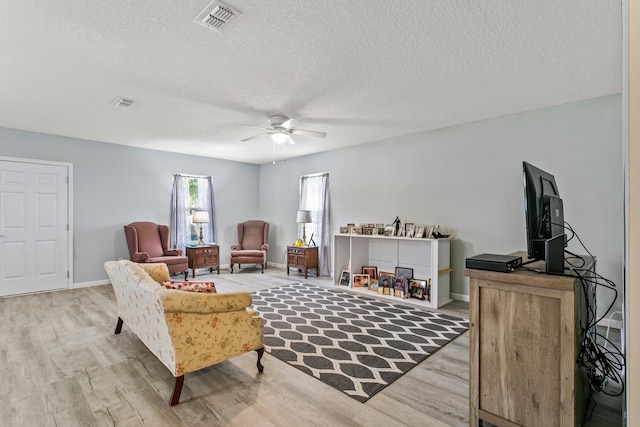 sitting room with ceiling fan, a textured ceiling, and light hardwood / wood-style flooring