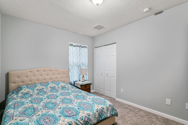 bedroom with carpet flooring, a closet, and a textured ceiling