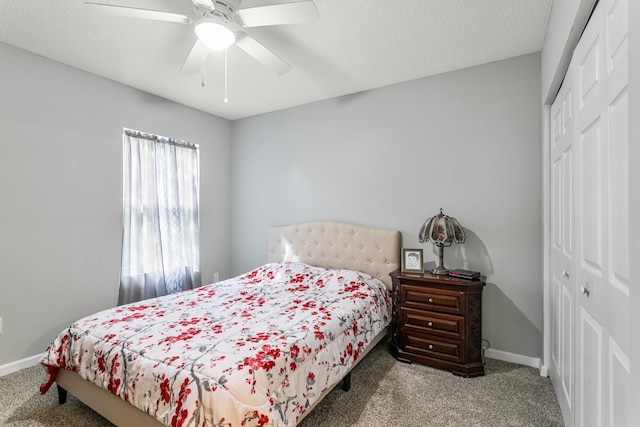 carpeted bedroom with ceiling fan, a closet, and a textured ceiling