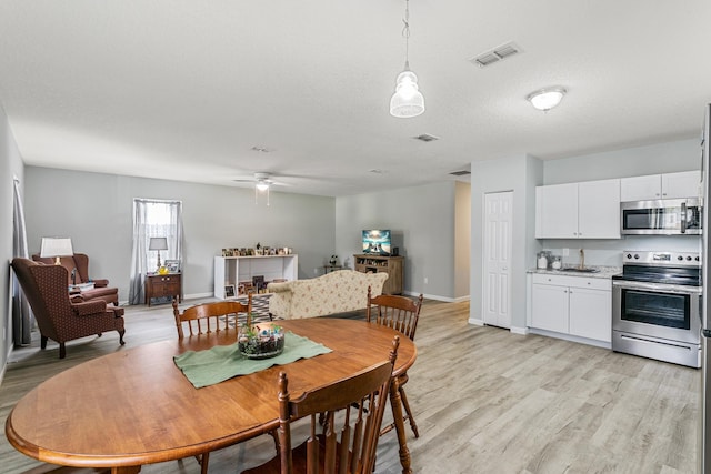 dining space featuring a textured ceiling, light hardwood / wood-style flooring, and ceiling fan