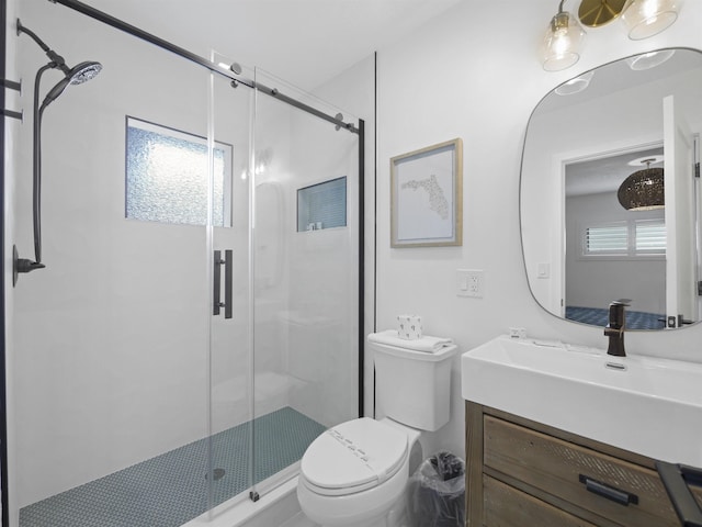 bathroom featuring toilet, a shower stall, and vanity