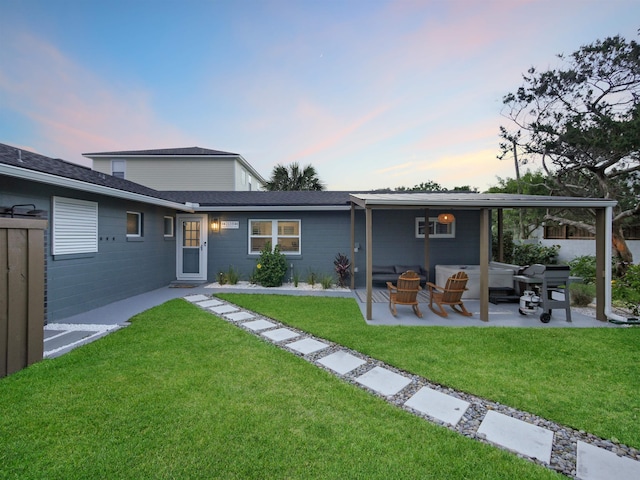 rear view of house featuring a patio, a lawn, and fence