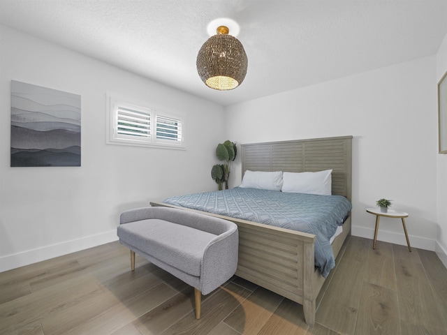 bedroom with baseboards and wood finished floors