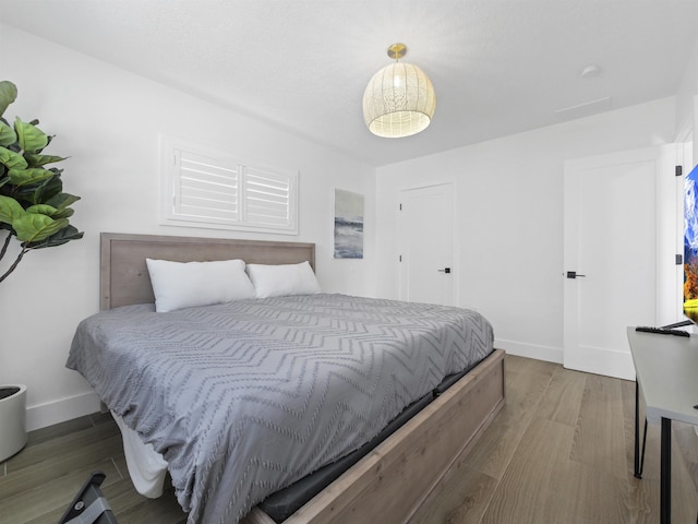 bedroom featuring wood finished floors and baseboards