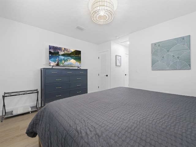 bedroom featuring light wood-style floors and visible vents