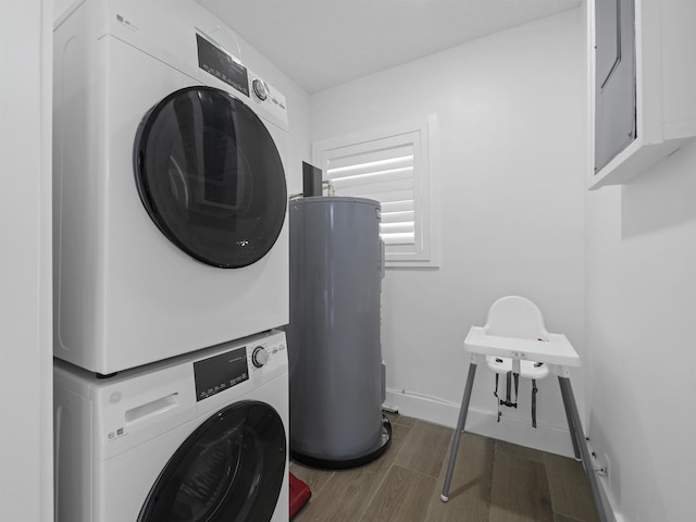 laundry room with laundry area, baseboards, stacked washer / dryer, wood tiled floor, and water heater