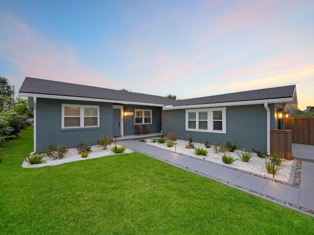 single story home with fence and a lawn