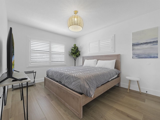 bedroom with baseboards and wood finished floors