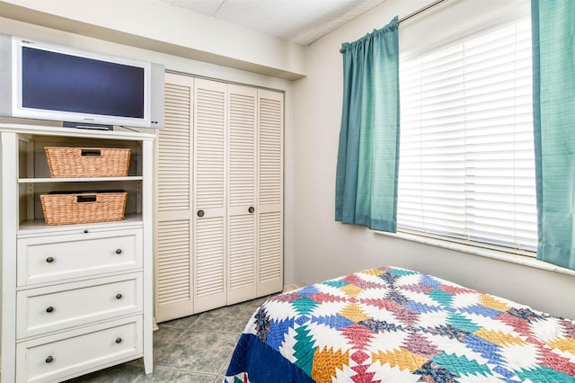 tiled bedroom with a closet