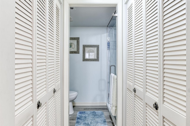 bathroom featuring toilet, hardwood / wood-style flooring, and an enclosed shower