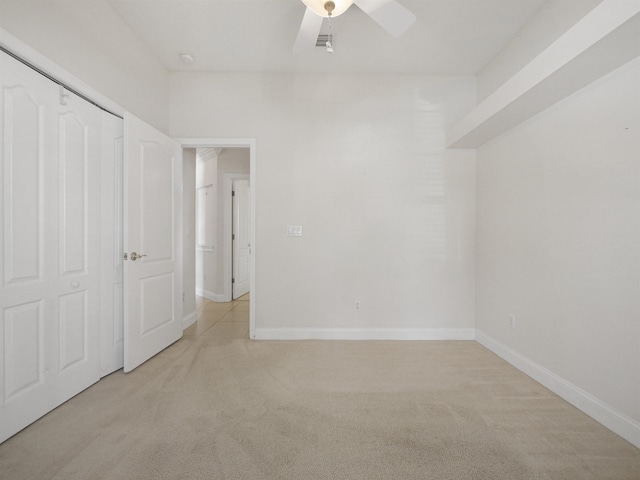 unfurnished bedroom featuring a closet, ceiling fan, and light colored carpet