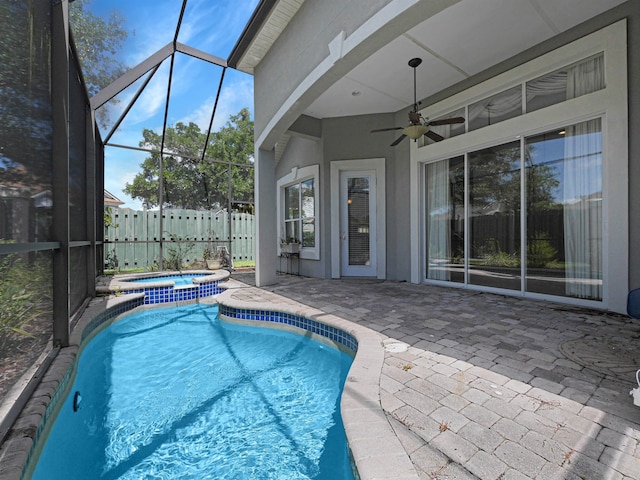 view of pool with glass enclosure, an in ground hot tub, ceiling fan, and a patio