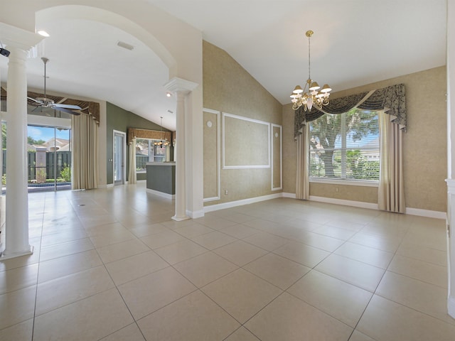 tiled empty room featuring ceiling fan with notable chandelier, vaulted ceiling, a healthy amount of sunlight, and ornate columns