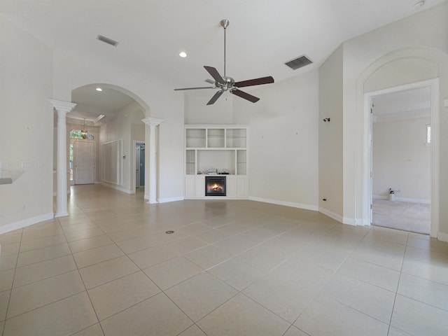 unfurnished living room featuring ceiling fan, light tile patterned floors, and ornate columns