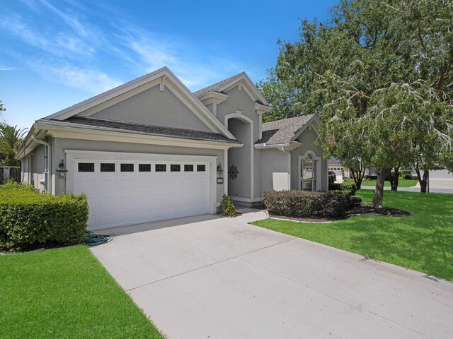 view of front of property featuring a garage and a front lawn