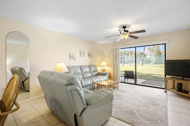 tiled living room featuring ceiling fan and a textured ceiling