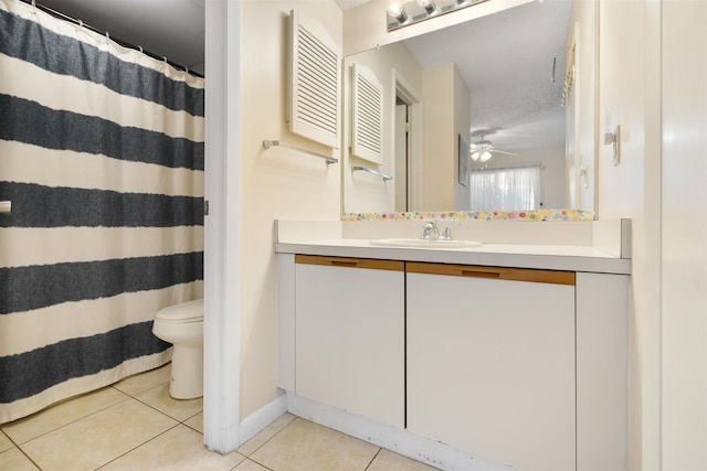 bathroom with vanity, tile patterned flooring, ceiling fan, toilet, and a textured ceiling