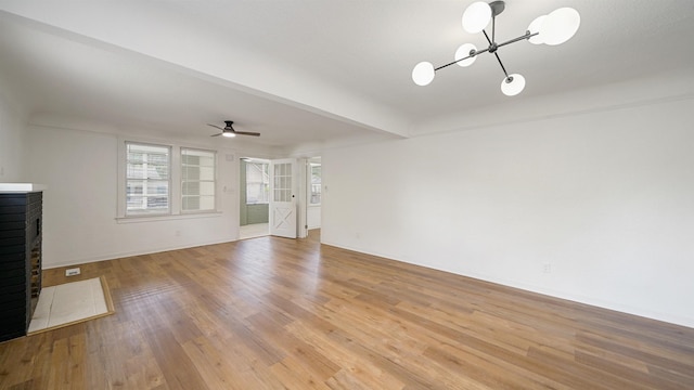 819 Mcduff Ave, Jacksonville, FL 32205 - unfurnished living room featuring light wood-style floors, ceiling fan with notable chandelier, and a fireplace