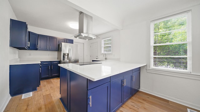 819 Mcduff Ave, Jacksonville, FL 32205 - kitchen with stainless steel fridge with ice dispenser, a peninsula, light wood finished floors, island range hood, and blue cabinetry