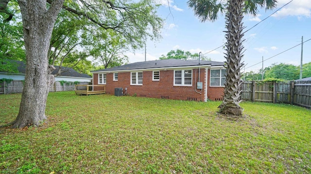 819 Mcduff Ave, Jacksonville, FL 32205 - back of property featuring brick siding, a fenced backyard, a wooden deck, and a lawn