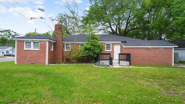 819 Mcduff Ave, Jacksonville, FL 32205 - rear view of house featuring brick siding, a chimney, and a lawn