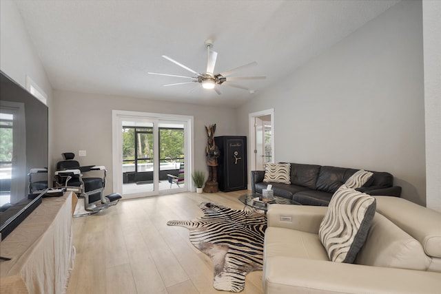 living area with ceiling fan, vaulted ceiling, and wood finished floors