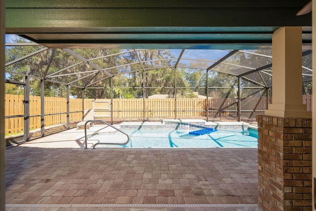 view of pool with glass enclosure, a patio area, a fenced backyard, and a fenced in pool