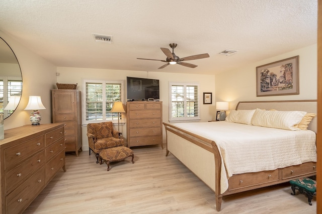 bedroom with light wood-type flooring, visible vents, and multiple windows