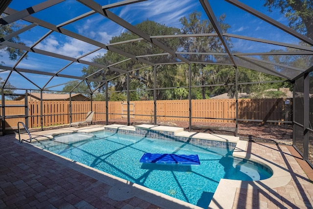 view of pool with glass enclosure, a patio area, a fenced backyard, and a fenced in pool