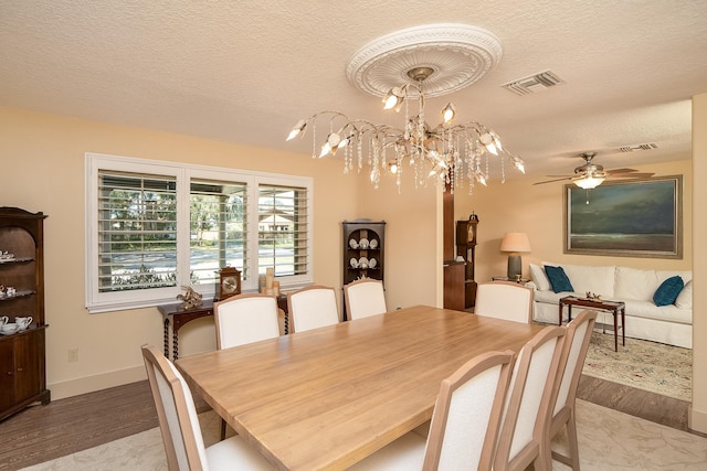 dining area featuring light wood-style floors, visible vents, and a textured ceiling