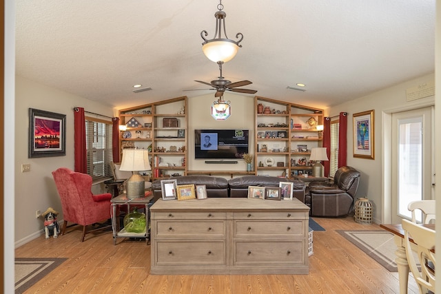 interior space with lofted ceiling, light wood finished floors, plenty of natural light, and a ceiling fan