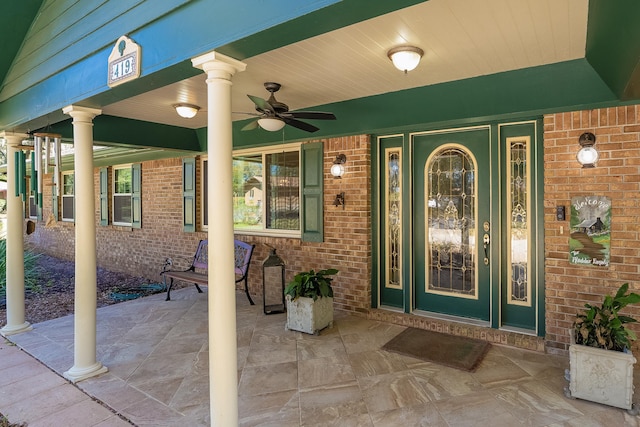 entrance to property with brick siding and ceiling fan