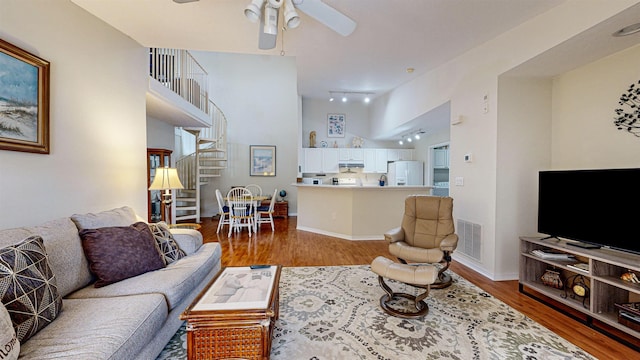 23213 Harbour Vista Cir, Saint Augustine, FL 32080 - living room featuring wood finished floors, ceiling fan, stairs, and a towering ceiling