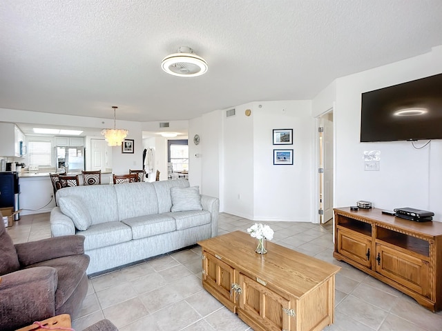 living room featuring light tile patterned floors, plenty of natural light, and a textured ceiling