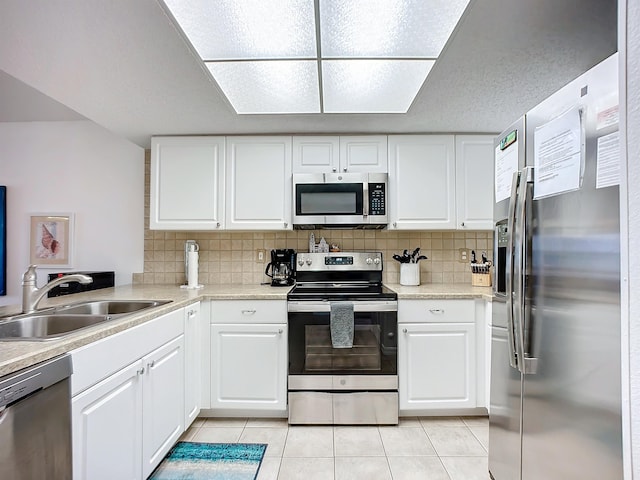 kitchen featuring stainless steel appliances, white cabinetry, and a sink