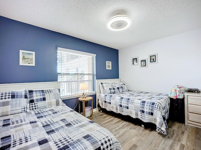 bedroom with a textured ceiling and wood finished floors