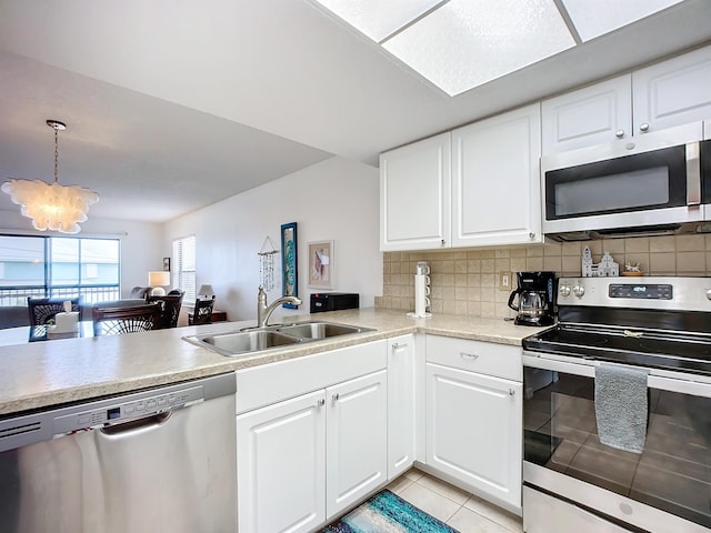 kitchen with a notable chandelier, appliances with stainless steel finishes, a sink, light countertops, and light tile patterned floors