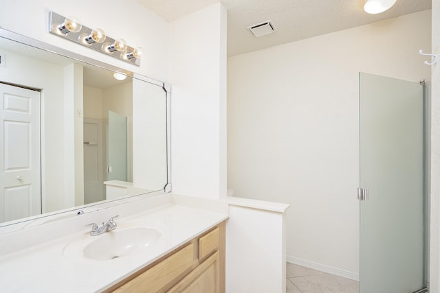 bathroom featuring tile patterned flooring, vanity, and walk in shower