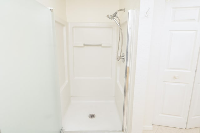 bathroom with tile patterned flooring and walk in shower